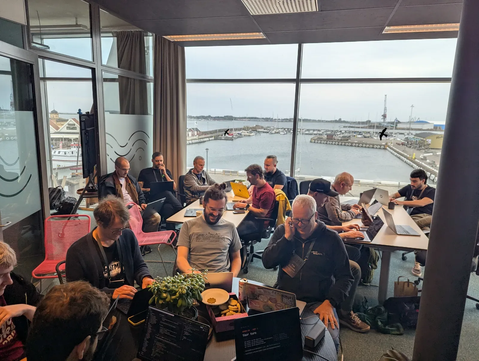 Workshop attendees at their laptops in a room overlooking Varberg harbour